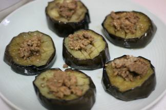 蒸好的茄子放在另一个盘子里，表面放上肉末。