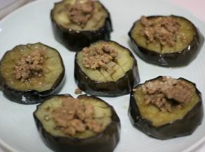 蒸好的茄子放在另一个盘子里，表面放上肉末。