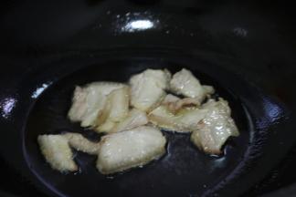 锅中烧热倒油，冷油下五花肉，小火煸炒出肥油。放入小米椒和姜蒜炒香