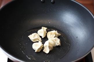 平底锅刷一层薄油。饺子摆放在锅内