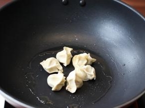 平底锅刷一层薄油。饺子摆放在锅内