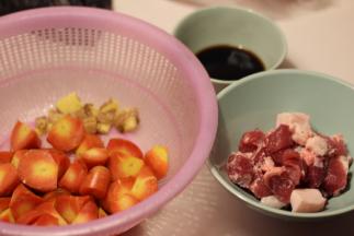 五花肉切块，胡萝卜滚刀切块，生姜拍碎，用生抽2勺+料酒2勺+盐1茶匙调成酱汁