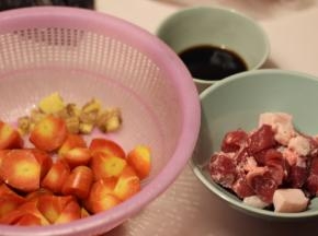 五花肉切块，胡萝卜滚刀切块，生姜拍碎，用生抽2勺+料酒2勺+盐1茶匙调成酱汁