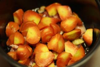 锅底倒上适量香油，把五花肉放进去，淋上酱汁，撒上生姜、冰糖和干辣椒，码上胡萝卜块