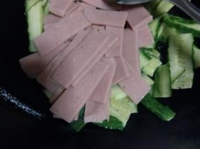 黄瓜炒到5-6成熟，把火腿片倒入锅中翻炒