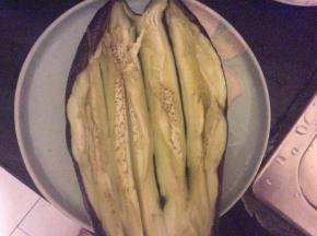 烤好后的茄子用刀剖开，茄肉切条但不切断