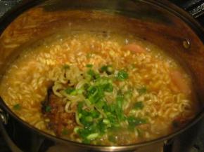 把煎好的鸡蛋放进去一起煮，放上一片芝士，撒上葱花关火