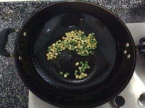 锅中热油，将豌豆和玉米粒倒入锅中翻炒