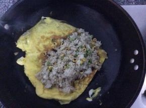 把炒好的炒饭倒在蛋皮上，包成蛋角状即可