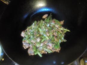 豆角炒熟后倒上肉片，翻炒均匀，加盐调味出锅
