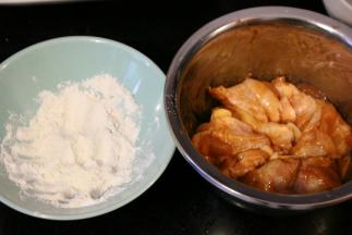 用面粉和淀粉混合做外衣，腌好的鸡块均匀的粘上这些粉状物