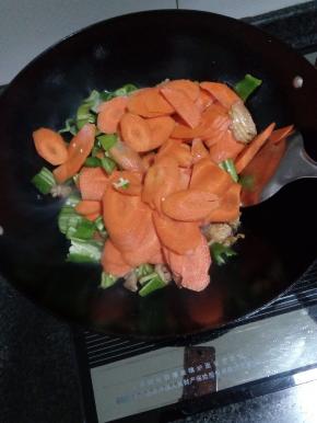 倒入胡萝卜和青椒，炒熟加盐调味，炒匀出锅