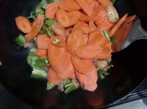 倒入胡萝卜和青椒，炒熟加盐调味，炒匀出锅