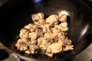 锅内放入油烧热，放入姜片爆香，放上焯好的鸡肉