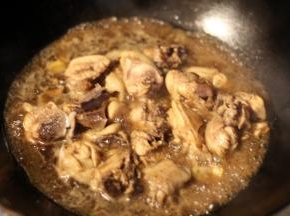 鸡肉翻炒变色后倒入米酒、酱油、白糖炒均，加盖大火烧开，转中小火慢炖