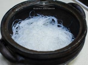 将泡好的粉丝均匀垫于黑砂锅底部，这锅可是俺故乡雅安的特产之一地道的荥经黑砂锅，老妈专门从家里带过来的
