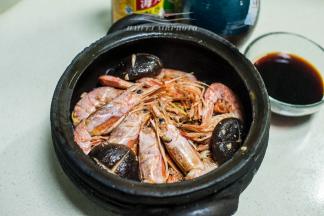 将炒制好的虾及辅料有成次的铺垫于黑砂锅中，将适量的生抽、耗油、花雕酒、水混合调制成汁，然后浇于锅中食材之上，略微和虾齐平为好
