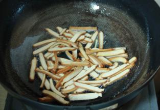 炒锅加热倒入食用油至7成油温后，置入香干煸炒