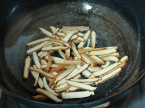 炒锅加热倒入食用油至7成油温后，置入香干煸炒