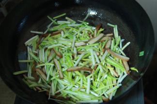 炒至香干微黄后加入切好的蒜黄，依次加盐，鸡精，生抽调味