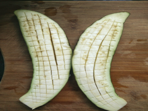 茄子对半切开，竖着划几刀，不要切透了。 