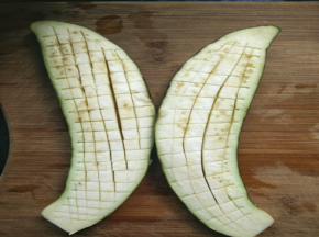 茄子对半切开，竖着划几刀，不要切透了。 