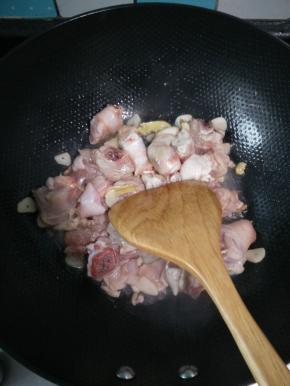 热锅凉油，油热之后将蒜片炒香，下入姜片翻炒，之后放沥干水的鸡腿翻炒。