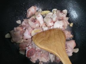 热锅凉油，油热之后将蒜片炒香，下入姜片翻炒，之后放沥干水的鸡腿翻炒。