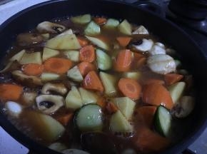 黄油化开，加入蒜，炒香，蔬菜块平铺，再铺上鸡翅（腌制鸡翅的姜丝蒜块不要）。如果锅底薄，可以适当加些开水，焖20分钟，鸡翅和蔬菜都很软而入味。如果不喜欢太烂，焖15分钟即可。