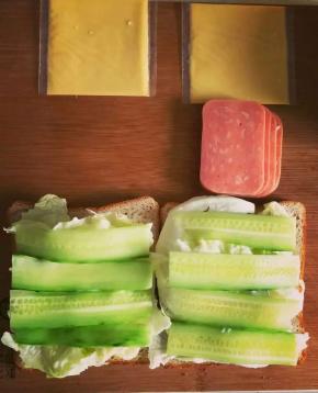 将洗净控水晾干的圆生菜平铺吐司片上，涂抹少许沙拉酱后，上面叠放黄瓜片。