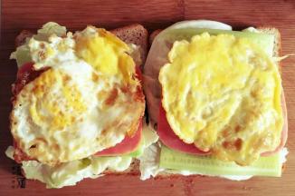 此时去热油煎鸡蛋，为了避免鸡蛋腥味过重，可在油温烧至较高时放入鸡蛋，小火煎至个人喜爱的状态，用吸油纸吸油后放置火腿片上。
 
