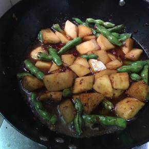 倒入豆角土豆翻炒 加入少许生抽 炒出颜色 并加入一碗水淹没土豆豆角 小火焖15分钟