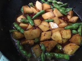 倒入豆角土豆翻炒 加入少许生抽 炒出颜色 并加入一碗水淹没土豆豆角 小火焖15分钟