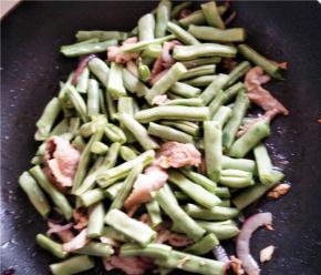 放入洗净沥干的豆角不断翻炒。