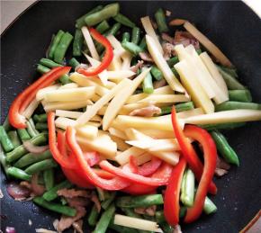 豆角变色后加入土豆甜椒快速大火翻炒，以防焦了，此时加入鸡精、花椒粉、耗油、生抽、五香粉调味。