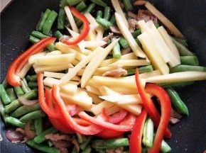 豆角变色后加入土豆甜椒快速大火翻炒，以防焦了，此时加入鸡精、花椒粉、耗油、生抽、五香粉调味。