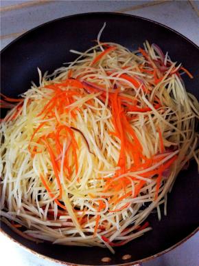 随后开大火，放入土豆丝，快速翻炒。加入鸡精、花椒适量，耗油少许，耗油的加入只是为了提鲜。断生后放盐，出锅，装盘。