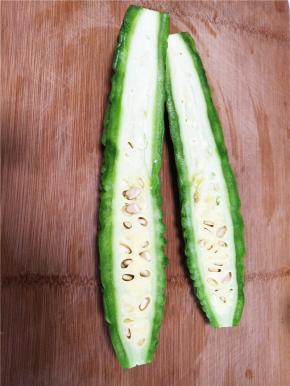 苦瓜横切一分为二，用勺子掏去中间白色部分，一定要尽可能的将白色部分刮净，不然会超级苦。