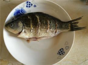 鲫鱼剖洗净后，正反面各划四刀，用料酒、盐和姜片腌制15分钟左右