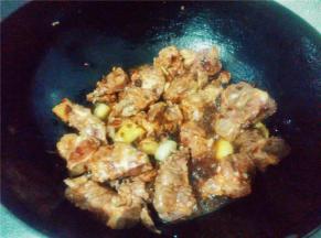 将排骨倒入锅中翻炒，炒至金黄