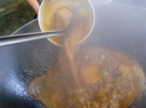 端来里脊肉，将锅中调料淋上