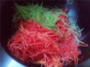 翻炒一分钟后倒入红萝卜丝和莴笋丝