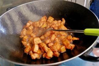 将肉块和金黄色的糖汁混合搅拌至到肉成金黄色