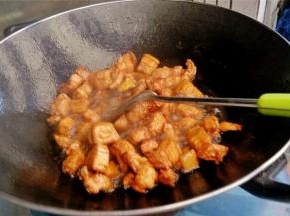 将肉块和金黄色的糖汁混合搅拌至到肉成金黄色