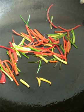 锅里放油放入切好的红辣椒、姜、葱炒出香味。