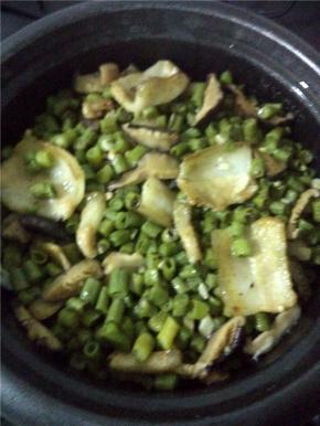 大米洗净，把大米和炒好的长豆角、五花肉一起倒入电饭锅，加少许盐。