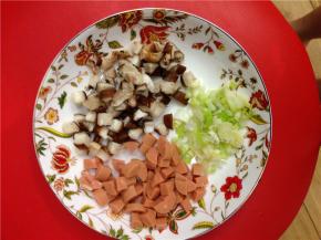 将鸡蛋炒成小块，盛出来。将蘑菇、火腿切成小丁，再切点葱丝。