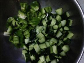 将青椒和黄瓜分别切成丁状备用，鸡丁提前放入锅中炒一下。