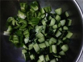 将青椒和黄瓜分别切成丁状备用，鸡丁提前放入锅中炒一下。