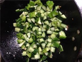 炒锅倒入少量油，烧热后加葱花炒香，将青椒和黄瓜倒入翻炒2分钟。 